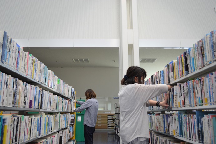 書架の本を正しい位置に並べなおしている